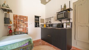 A compact kitchen with a tiled backsplash, a microwave, and a small refrigerator. - Provencal farmhouse, warm and cozy, nestled in the heart of the pool gardens. (Salernes)