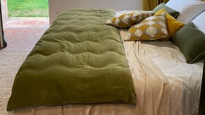A bedroom with a bed, a window, a door, and a small shelf. - Provencal farmhouse, warm and cozy, nestled in the heart of the pool gardens. (Salernes)