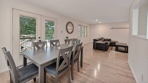 A spacious living room with a dining area, a large window, and a view of the outdoors. - Lake Gaston Duo Side B Kayak, Water mat, Gameroom (Bracey)