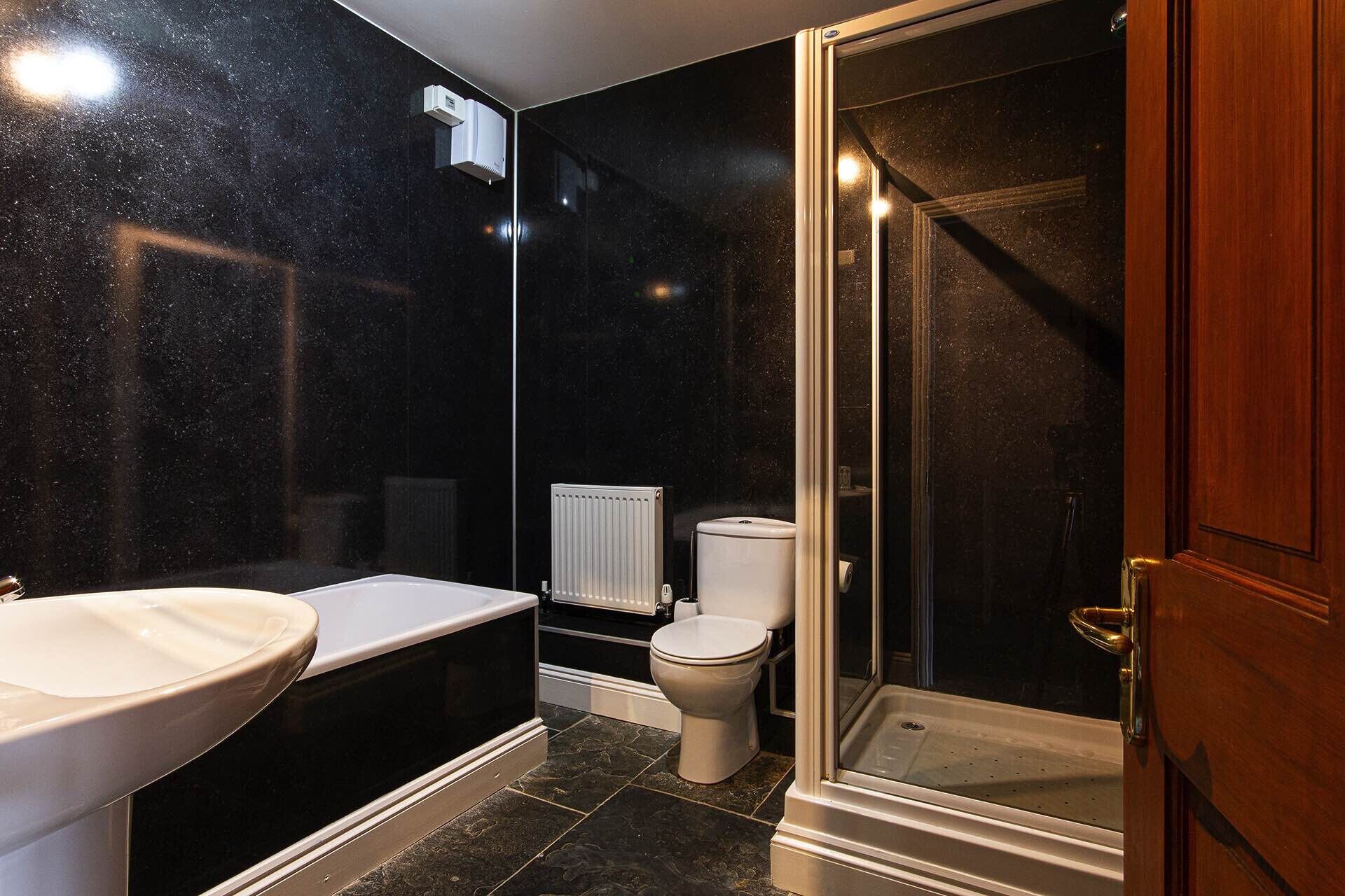 A bathroom with a bathtub, toilet, and shower area.