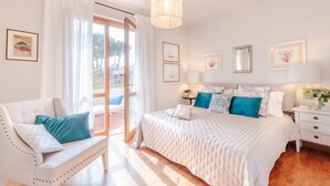A bedroom with a bed, a chair, a nightstand, and a window with curtains. - Regina Beach, Luxury 3 bedrooms Villa by the Beach in Marina di Pietrasanta (Marina di Pietrasanta)