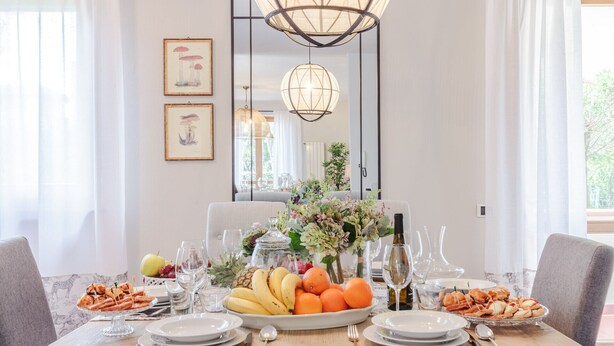 A dining table set with plates, glasses, and a variety of food including fruits and pastries. - Regina Beach, Luxury 3 bedrooms Villa by the Beach in Marina di Pietrasanta (Marina di Pietrasanta)