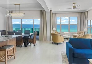 Ein modernes Hotelzimmer mit Balkon, Essbereich und einer Sitzecke mit Meerblick.
