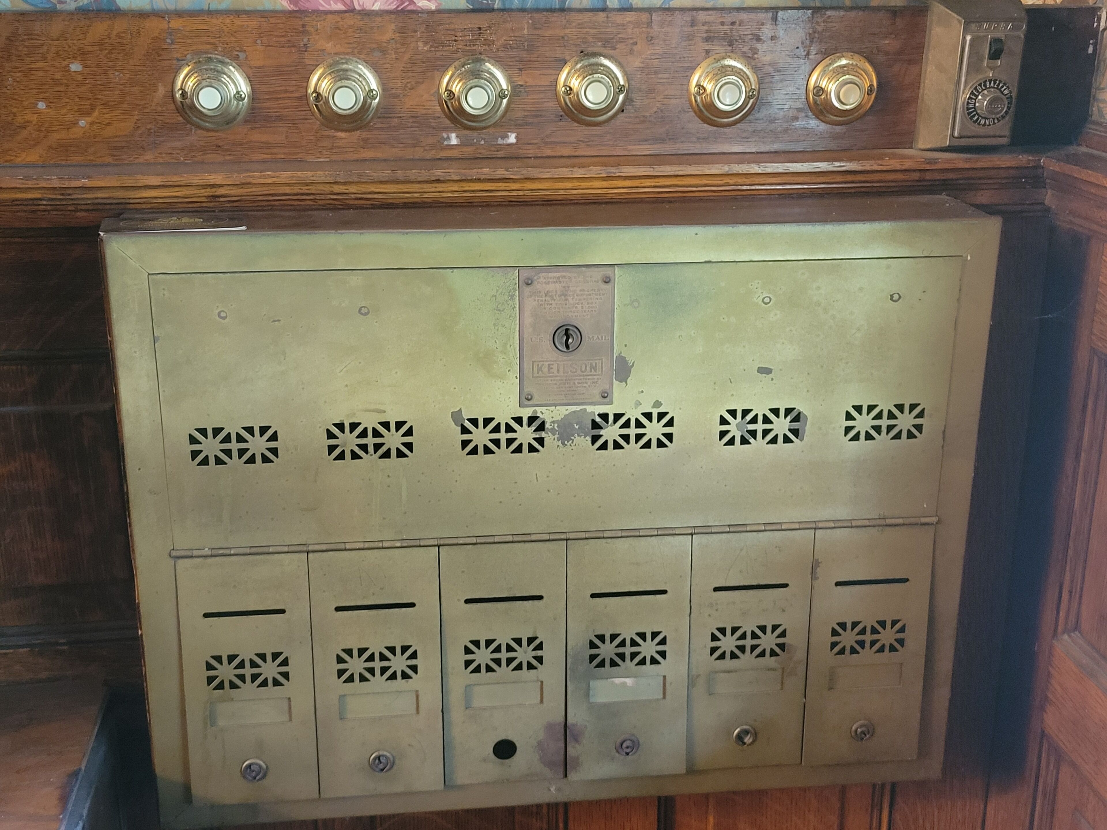 A vintage-style elevator with a wooden panel and brass handles.