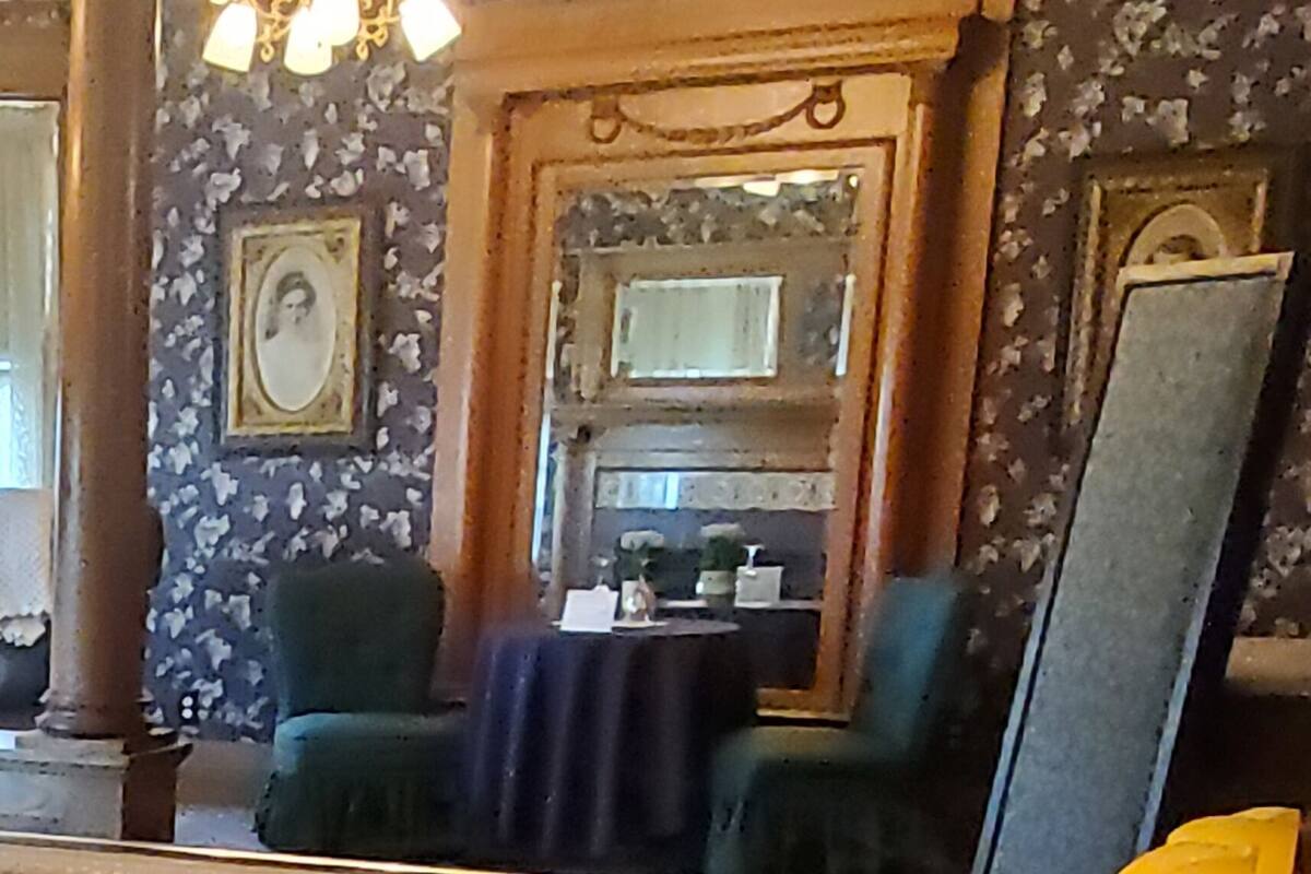 A bathroom with a sink, mirror, and multiple candles on a stand.