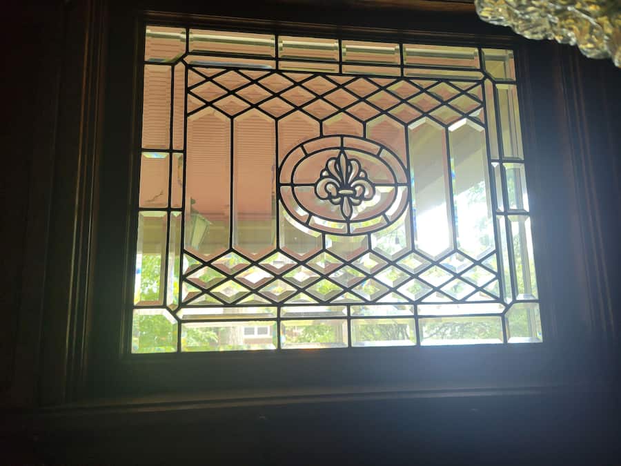 Una ventana con un diseño geométrico y un emblema central.