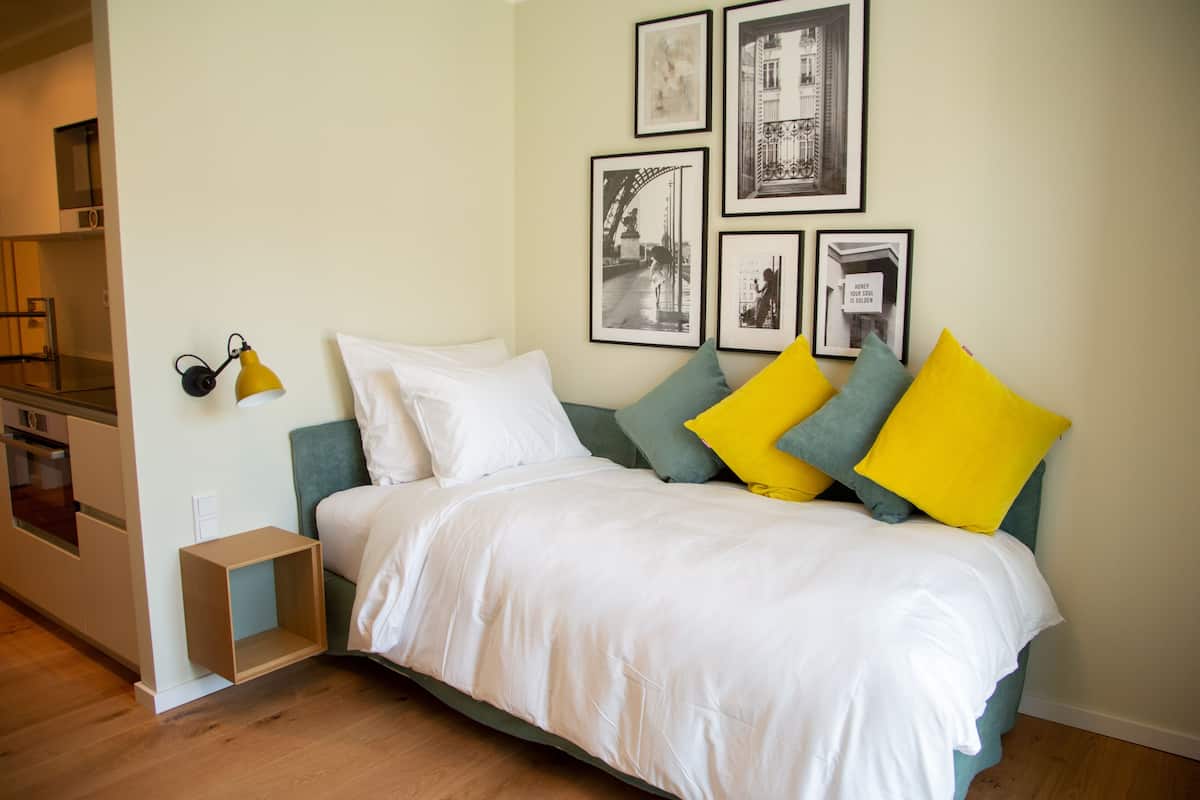 A neatly arranged bedroom with a bed, pillows, and a bedside table.