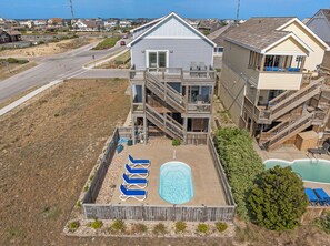 Ein mehrgeschossiges Haus mit Pool, Sitzgelegenheiten im Freien und einer Treppe.