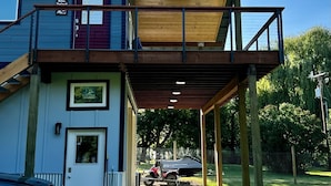 A two-story house with a balcony, a garage, and a driveway. - Spectacle Lake Waterfront Retreat Chalet (Tonasket)