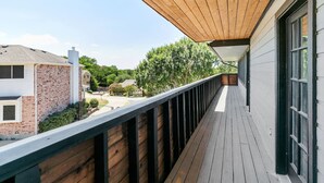 A wooden deck with a view of neighboring houses and trees. - Amazing and Comfortable Home in Grand Prairie! (Grand Prairie)