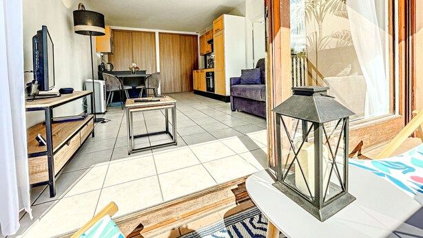 A modern living room with a dining area, a sofa, a coffee table, and a TV. - Annecy 1 bedroom Apt With Balcony (Annecy)