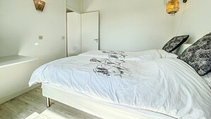 A bedroom with a bed, two wall-mounted lights, a door, and a white wall. - Annecy 1 bedroom Apt With Balcony (Annecy)