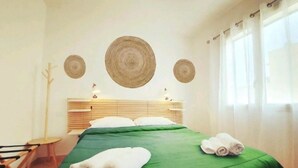 A hotel room with a bed, a chair, and a window with curtains. - SUD12 - Case vacanze (Mazara del Vallo)