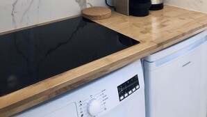 A kitchen with a black induction cooktop, a microwave, a coffee maker, and a dishwasher.