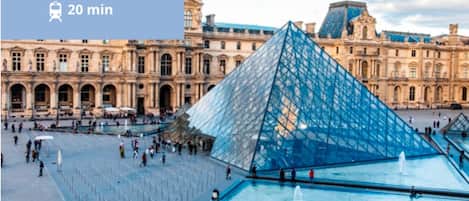 El patio del Museo del Louvre, con la icónica pirámide de cristal y el histórico Palacio del Louvre al fondo.