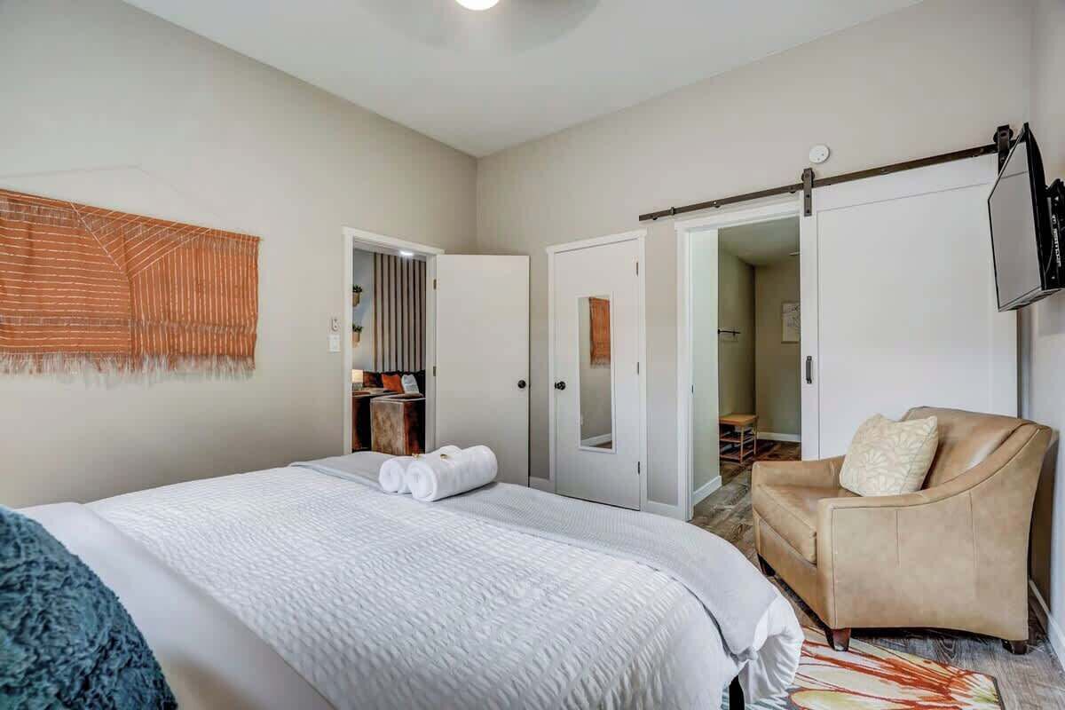 Une chambre d’hôtel avec un grand lit, un canapé, une télévision et une armoire.