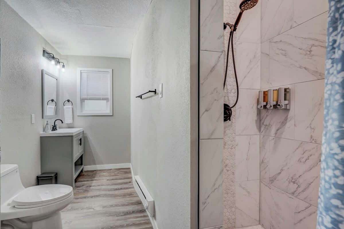 Une salle de bain comprenant des toilettes, un lavabo et un espace douche.