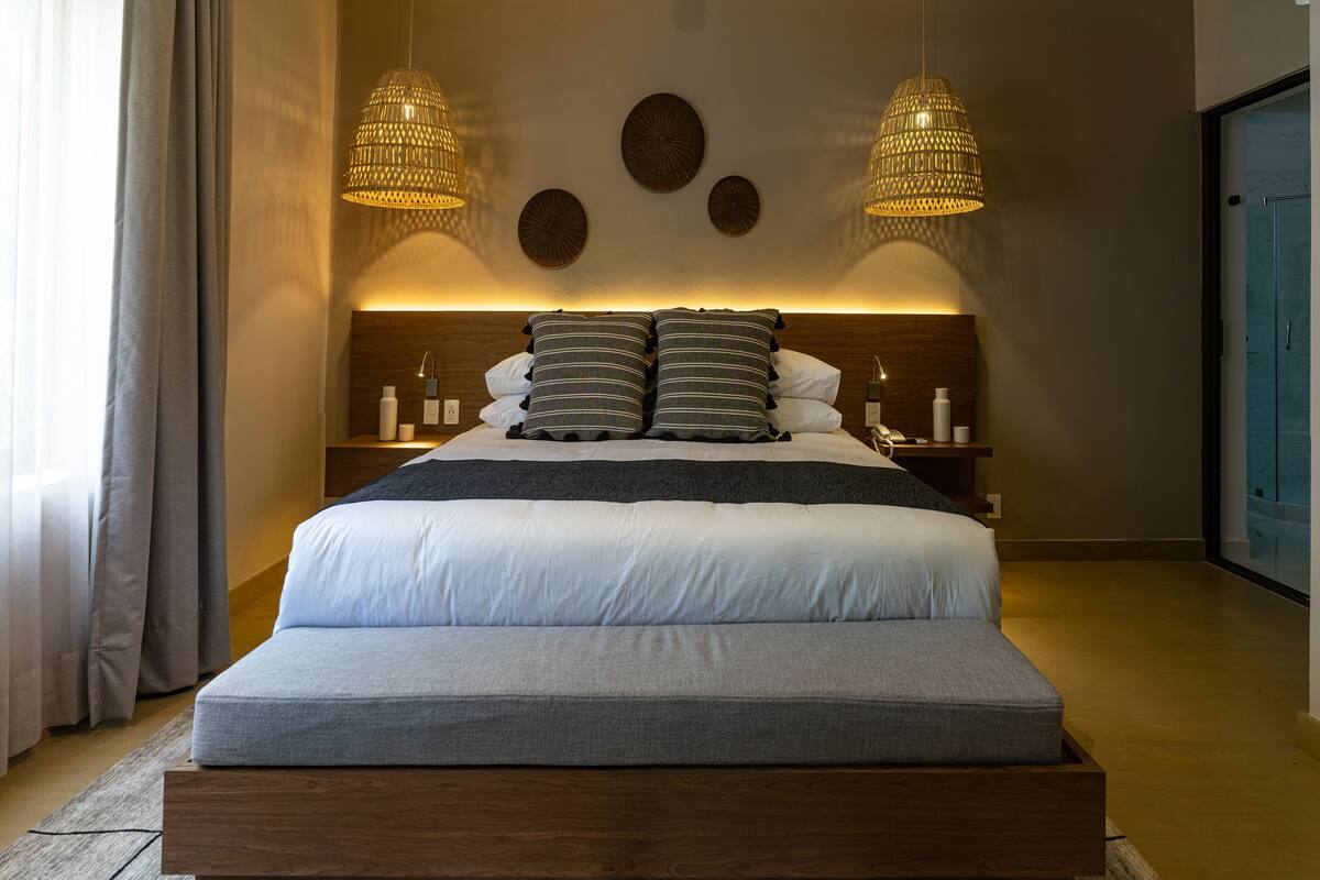 Une chambre à coucher moderne avec un grand lit, deux lampes de chevet et une table de chevet avec une lampe.