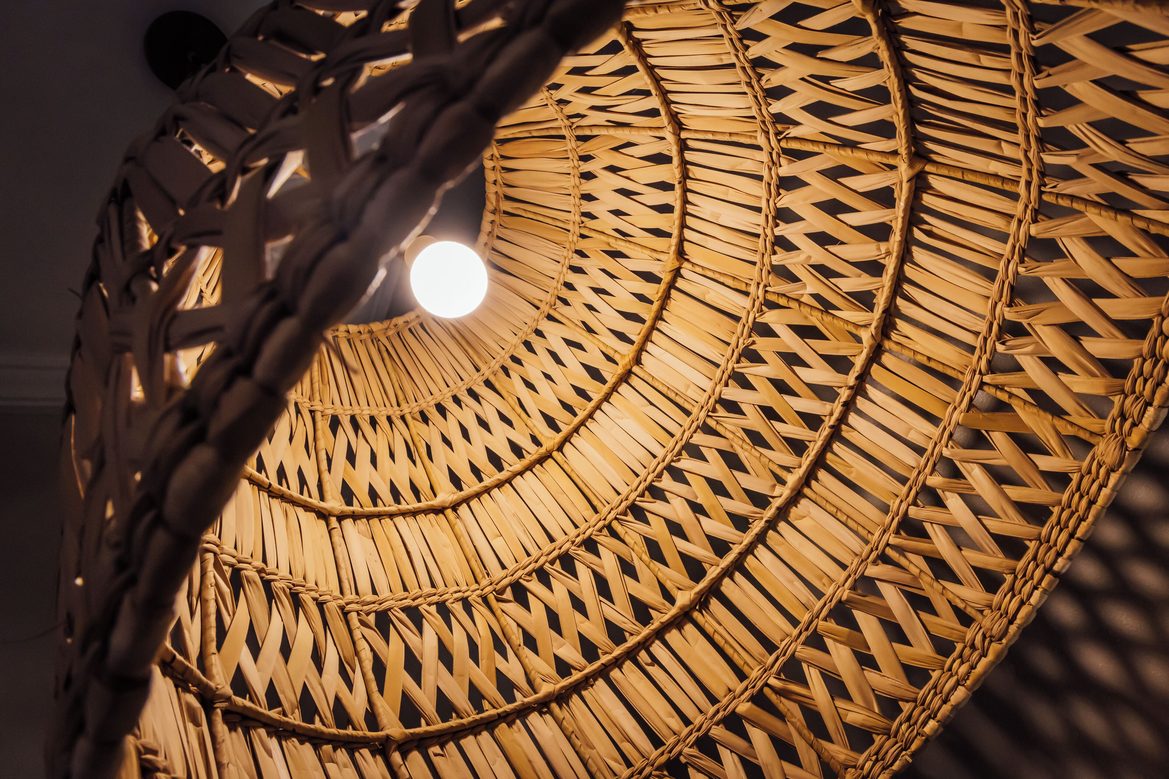 Una estructura circular tejida con una fuente de luz en el centro.