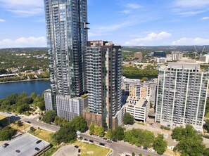 A high-rise building with multiple floors, surrounded by other buildings and a body of water. - Stylish 1BR Austin Escape w/ Heated Rooftop Pool (Austin)