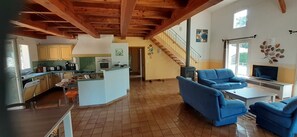 A spacious living area with a kitchen, blue sofas, a TV, and a staircase. - Detached house with private pool 2 km from Vallon-Pont-d'Arc (Salavas)