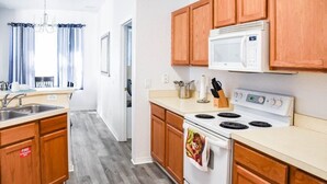 A kitchen with wooden cabinets, a white stove, and a microwave. - HR135HS - Highlands Reserve - 4 beds pool home close to Disney (Davenport)