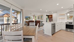 Eine moderne Küche mit weißen Schränken, einem Holztisch und einem eingebauten Backofen.