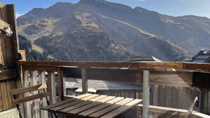 A wooden balcony with a table and chairs, overlooking a mountainous landscape. - Immodreams - Le Dahu - Avoriaz (Avoriaz)