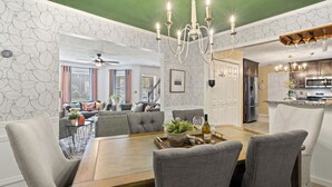 A dining area with a wooden table, grey upholstered chairs, and a chandelier. - ✨Boutique 4BR Retreat in Duluth 🏡✨Sleeps 8✨25 min to ATL (Duluth)
