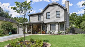 A two-story house with a stone entryway, a front porch, and a well-maintained lawn with a flower bed. - ✨Boutique 4BR Retreat in Duluth 🏡✨Sleeps 8✨25 min to ATL (Duluth)