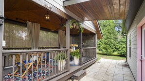A covered porch with a wooden deck, outdoor seating, and potted plants. - ✨Boutique 4BR Retreat in Duluth 🏡✨Sleeps 8✨25 min to ATL (Duluth)
