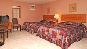 A hotel room with two beds, a desk with a chair, a television, and a lamp. - Gaudet Chalets & Motel (Shediac)
