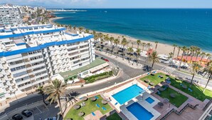 A hotel with a pool, a beach view, and a parking area. - MalagaSuite Aloha Playa (Benalmádena)