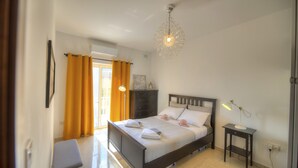 Une chambre à coucher avec un lit, une table de chevet, une lampe et une fenêtre avec des rideaux.
