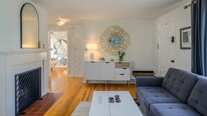 Un salon moderne avec une cheminée, des meubles blancs et un élément décoratif mural.
