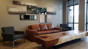 A modern living room with a large wooden coffee table, a brown leather sofa, and two armchairs. - Beautiful unit overlooking Mountain ski in ski out luxury property (Breckenridge)