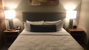 A neatly made bed with white linens, two bedside lamps, a phone, and a small table with a book and a lamp on each side. - Beautiful unit overlooking Mountain ski in ski out luxury property (Breckenridge)