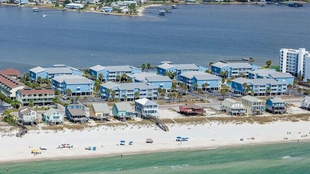 A coastal hotel with multiple buildings, a beach, and a marina. - Pet Friendly 3 BR Condo across from beach! (Gulf Shores)