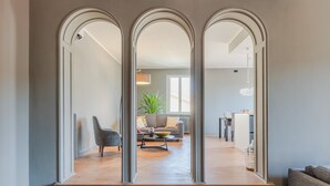 A modern interior with a staircase leading to a living area, featuring a sofa, coffee table, and dining table. - Casa Grey Contemporary Penthouse (Lucca)