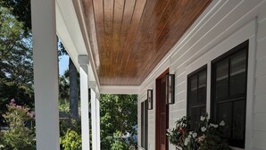 A covered porch with a wooden ceiling, white siding, and a brick pathway leading to a door. - Charming 4b/3b Newly Constructed Home on Dataw Island - Available 5/15 - 10/15 (Dataw Island)