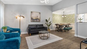 Una sala de estar moderna con sofá, mesa de centro y comedor.