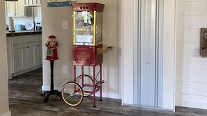 A hallway with a vintage popcorn cart, a bicycle, and two wall signs.