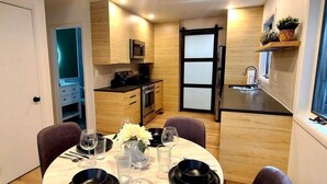 Una cocina compacta con muebles de madera, un microondas y un lavamanos.