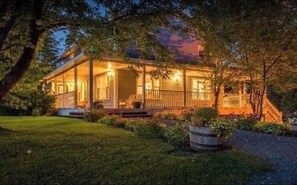 A two-story house with a porch, surrounded by trees and a well-maintained lawn. - Large, private house with ocean views! (Inverness)