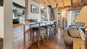 Un intérieur en bois avec un coin bar, des tabourets et un canapé.