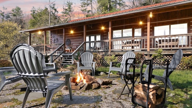 Une cabane dotée d’une véranda, d’un espace salon extérieur et d’un foyer.