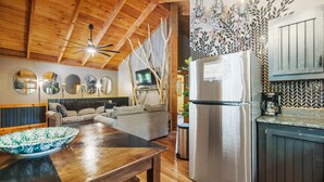 A wooden ceiling, a kitchen with a refrigerator, a dining table, and a sofa in a living area. - Under 1 mile from Natural Bridge State Park! (Slade)