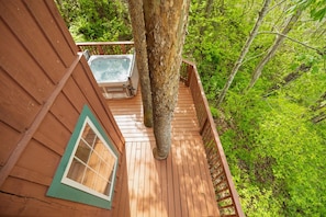 A wooden deck with a hot tub, surrounded by lush greenery. - Just 1 mile from Natural Bridge State Park! (Slade)
