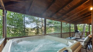 A hot tub on a wooden deck with a view of trees. - Nestled in a scenic backdrop with captivating mountain valley view (Rogers)
