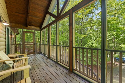 Log Home with fenced in deck & screen porch, cosmopolitan style ranch design.